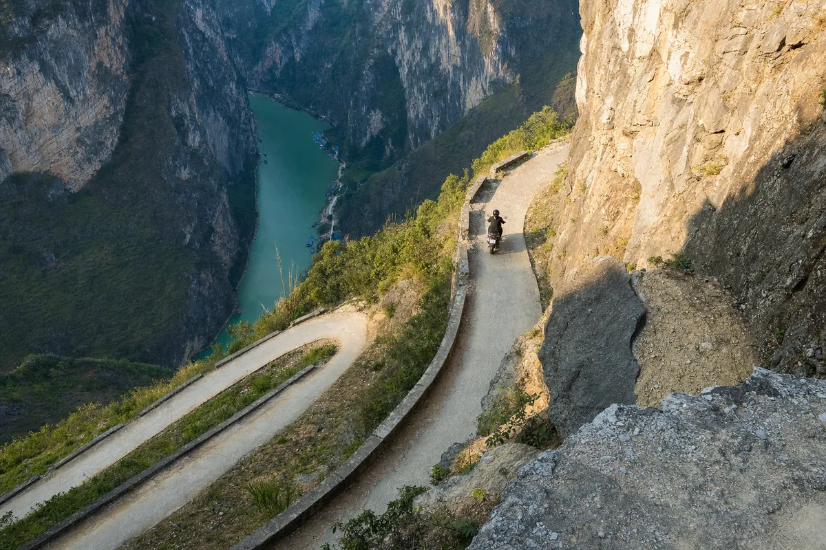 Steep access road descending from Ma Pi Leng Pass to the Nho Que River boat pier far below.