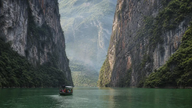Jade-green Nho Que River boat passing through the towering limestone walls of Tu San Canyon below Ma Pi Leng Pass