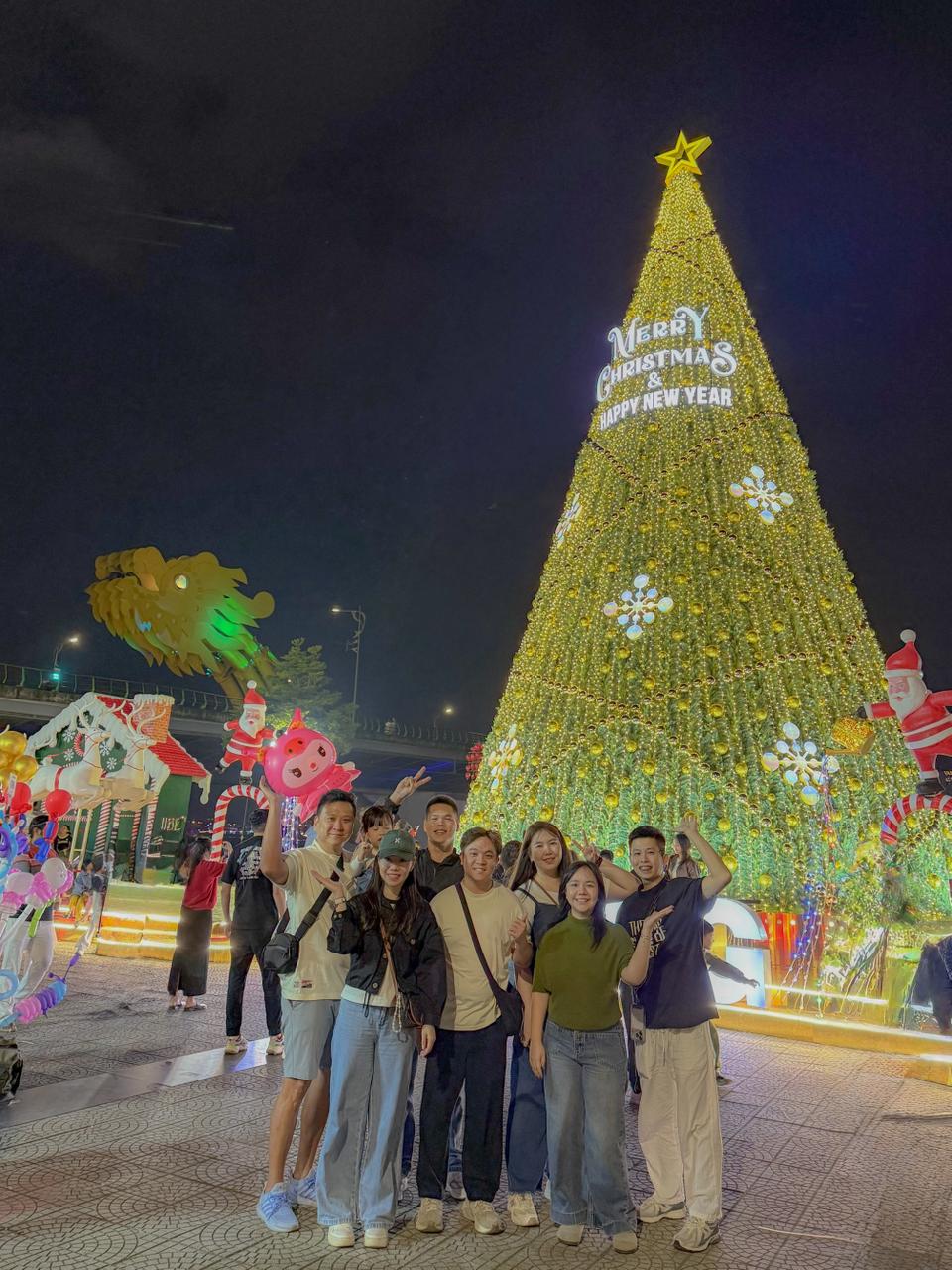 Group photo by Christmas tree at night