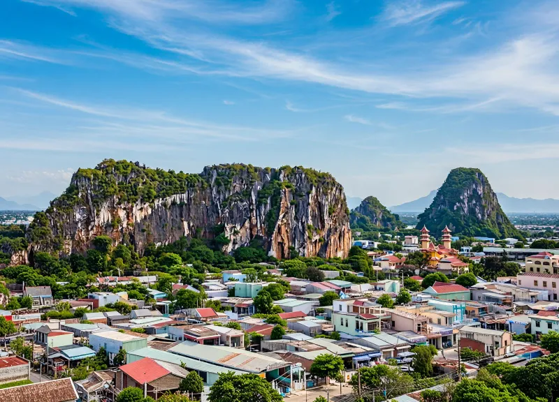Marble Mountains rising above Da Nang township under blue skies