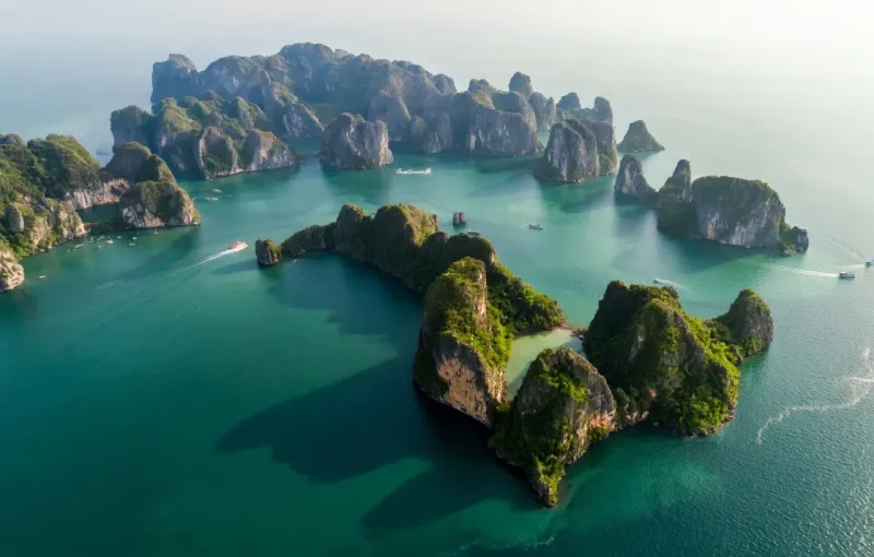 Aerial view of forested limestone karst islands rising from the emerald waters of Ha Long Bay