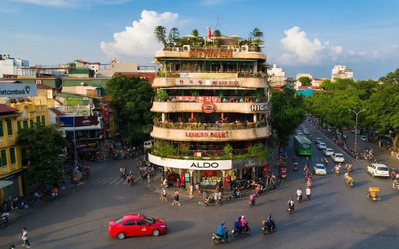 Aerial view of the Hanoi Old Quarter flatiron building with motorbike traffic at a busy intersection