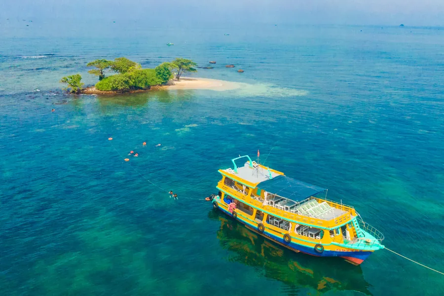 Wooden boat on crystal-clear turquoise water off North Phu Quoc